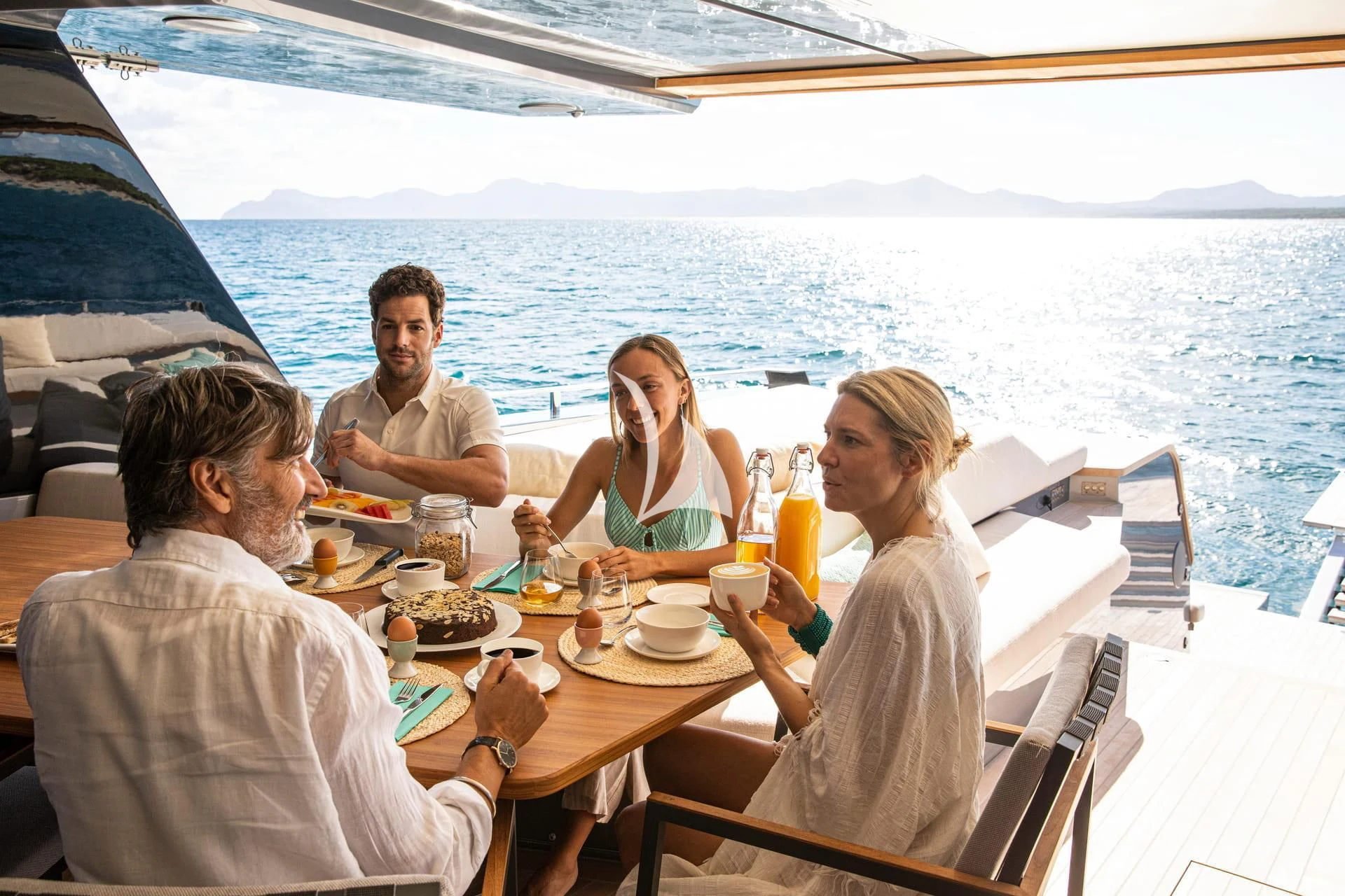 a group of people sitting around a table on a boat aboard WHY 200 Yacht for Sale