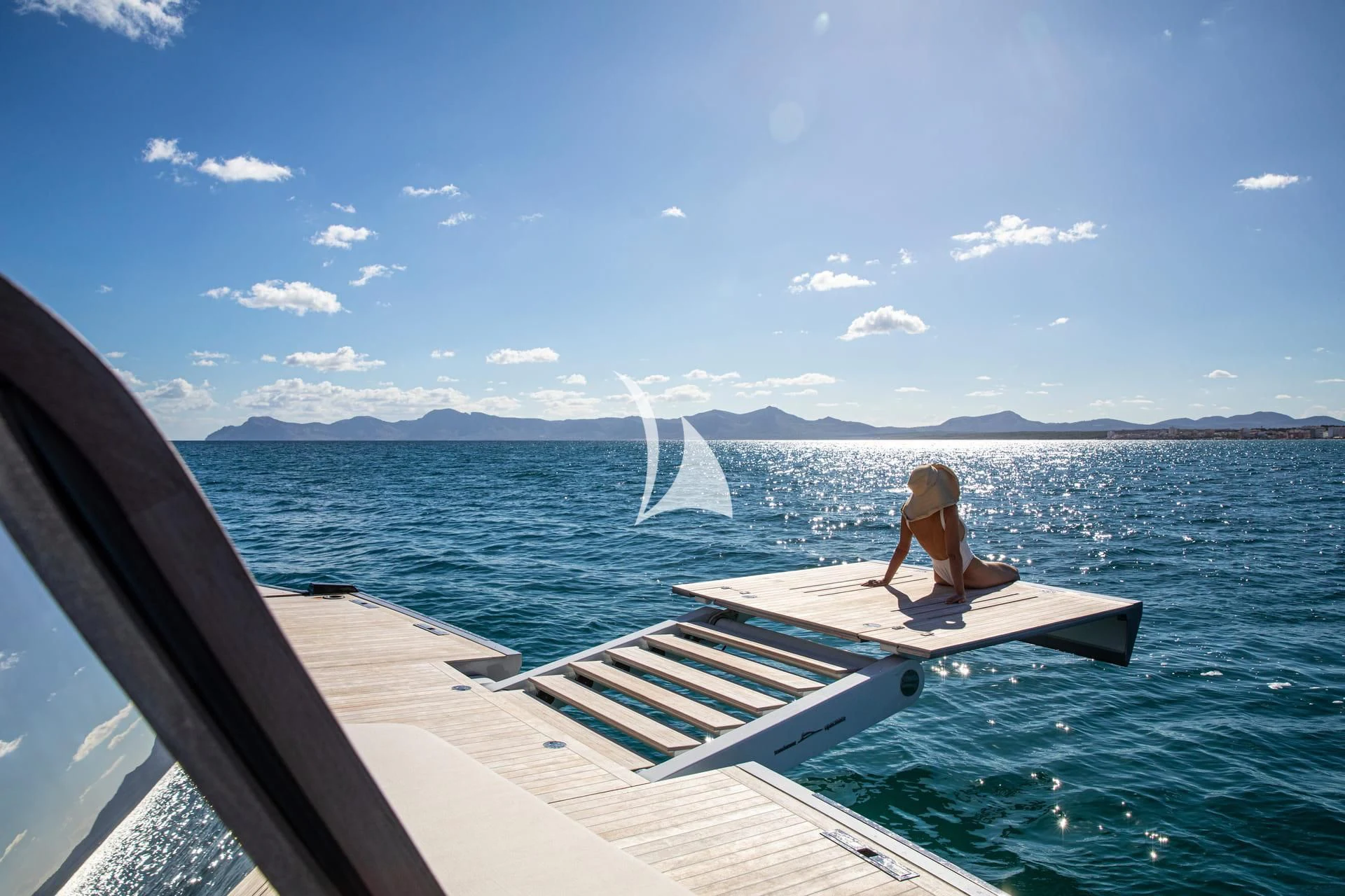 a person sitting on a dock on a boat in the water aboard WHY 200 Yacht for Sale