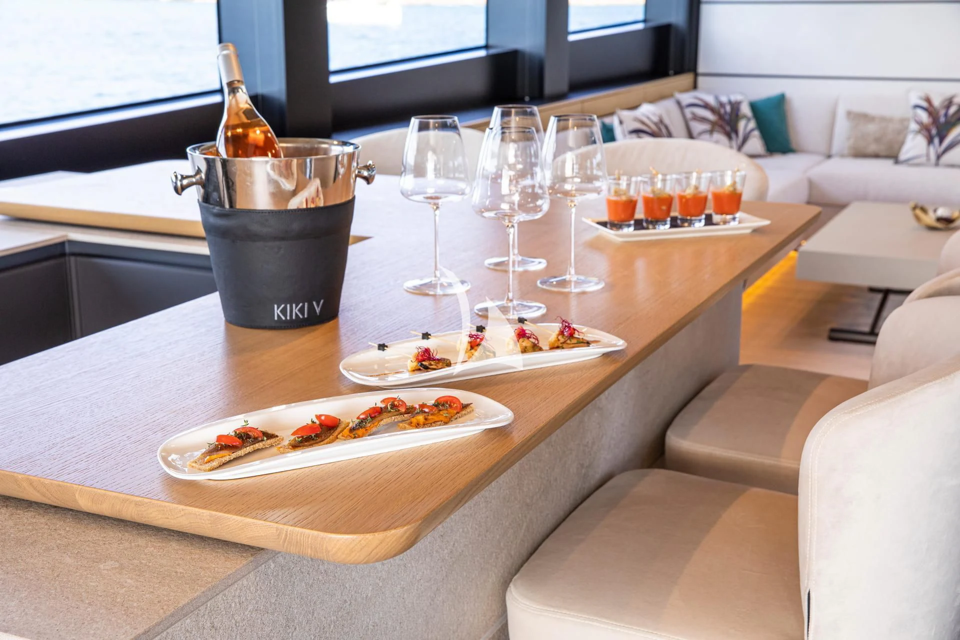 a table with a bottle of wine and a plate of food on it aboard WHY 200 Yacht for Sale