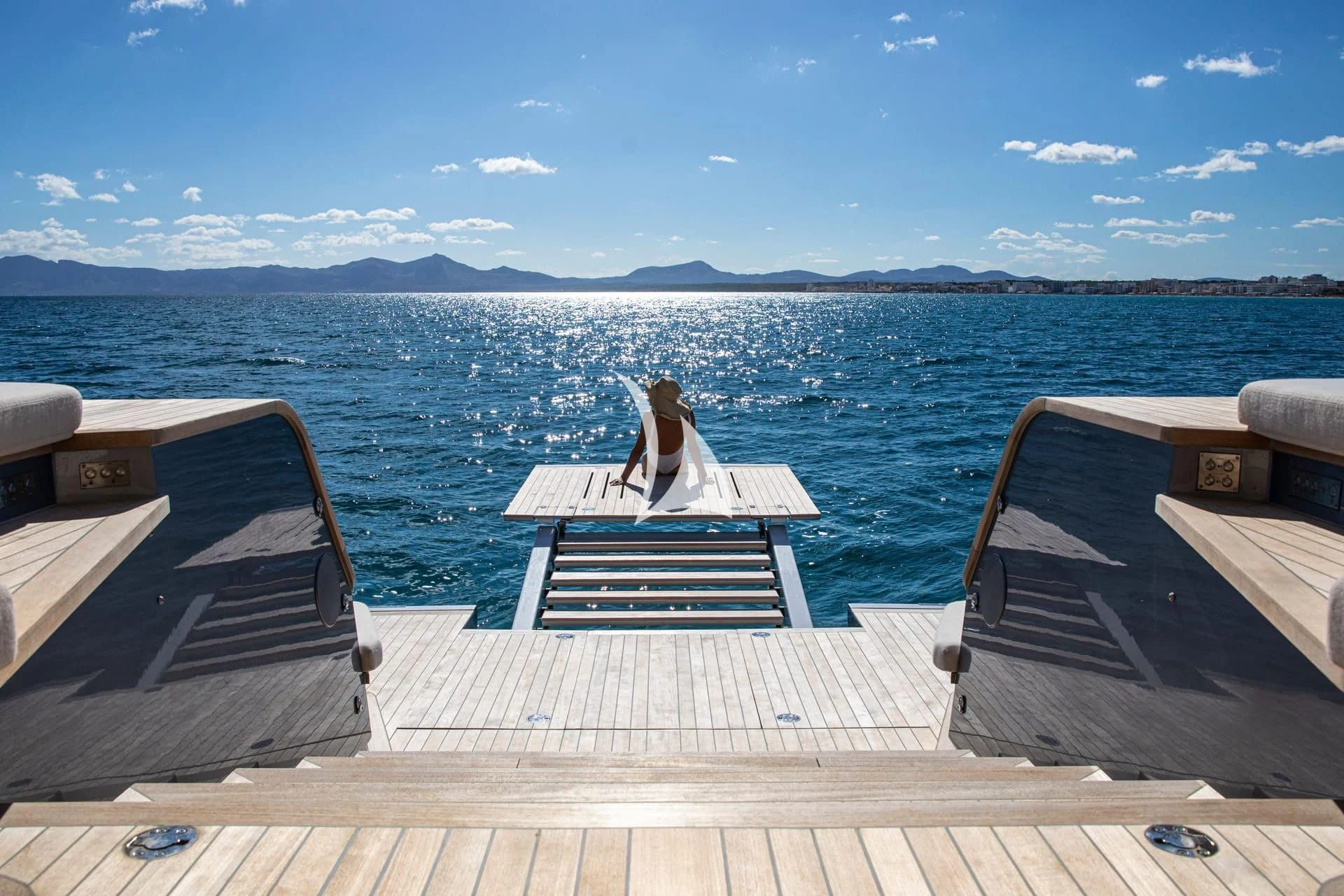 a person sitting on a chair on a deck overlooking a body of water aboard WHY 200 Yacht for Sale