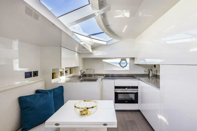 a kitchen with a table and a couch aboard CRAZY Yacht for Sale