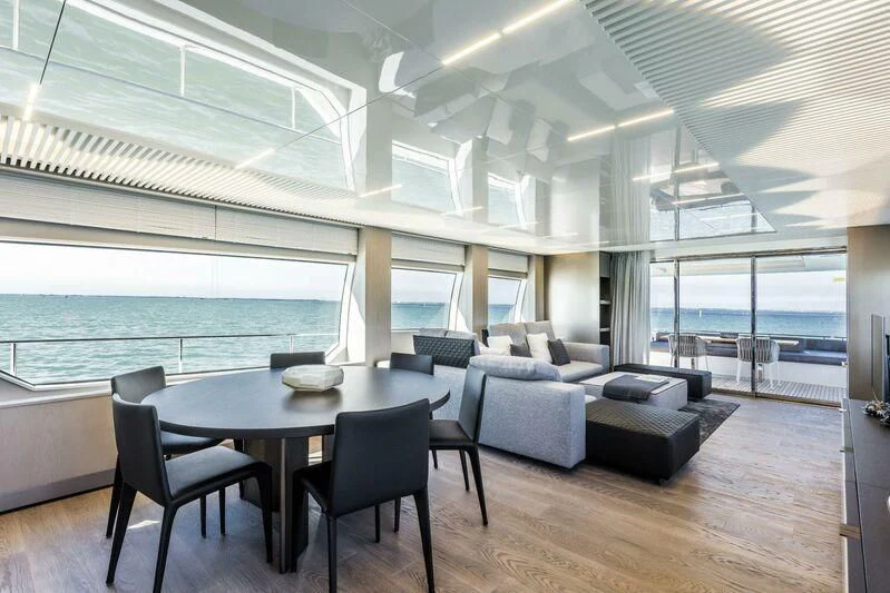 a large room with a table and chairs aboard CRAZY Yacht for Sale