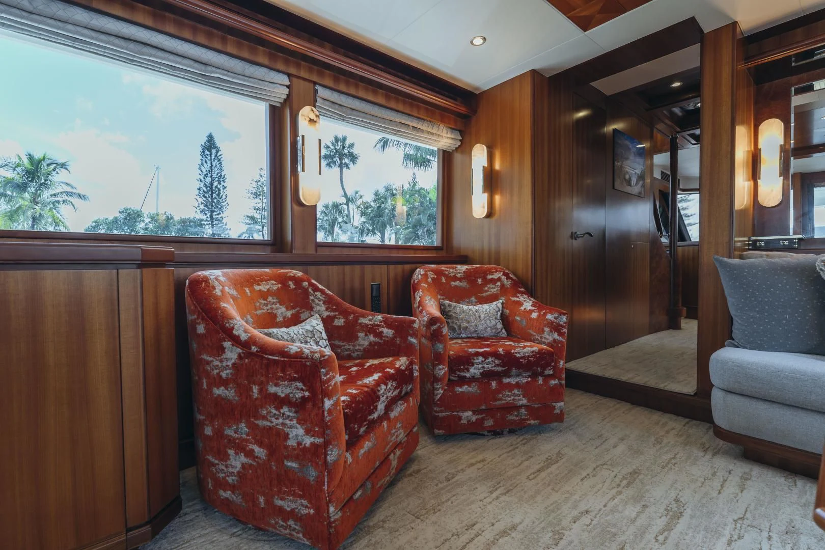 a couple of red chairs in a room with a large window aboard SKULLDUGGERY Yacht for Sale