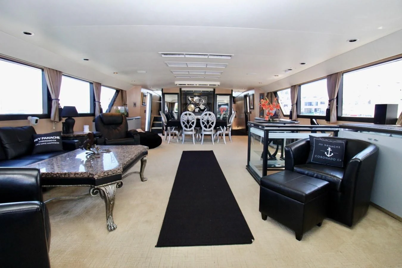 a living room with a black couch and a black table aboard PANACHE Yacht for Sale