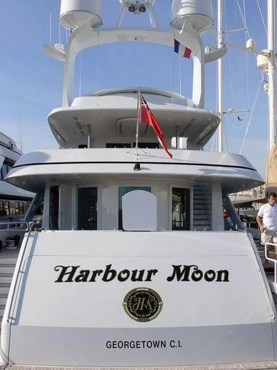a white boat with a red flag on it aboard HARBOUR MOON Yacht for Sale