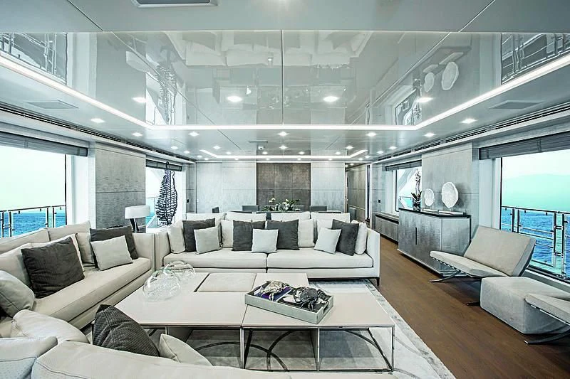 a living room with a large white couch and a large window aboard DELIBERATELY LUCKY Yacht for Sale