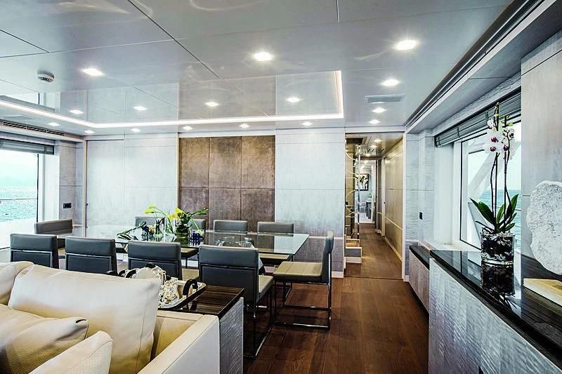 a large room with a long wood floor and a long wood table with chairs and a large window aboard DELIBERATELY LUCKY Yacht for Sale