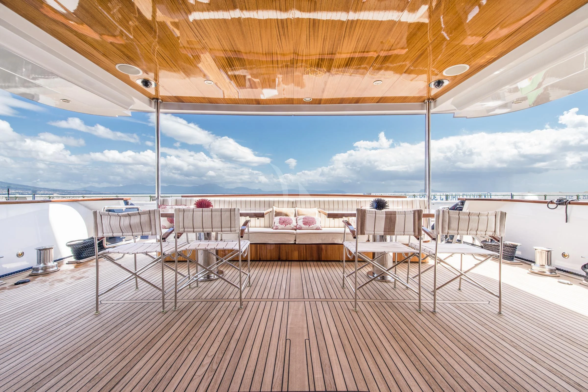a deck with tables and chairs aboard ANGRA TOO Yacht for Sale