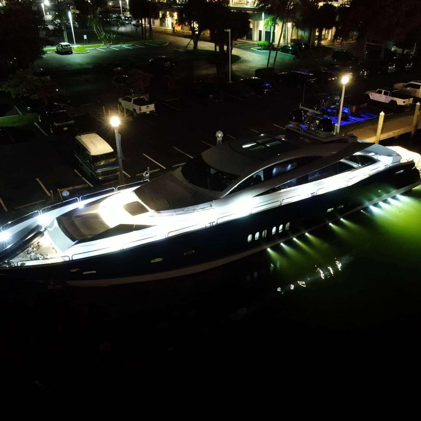 a white boat on a dock at night aboard SKY FALL Yacht for Sale