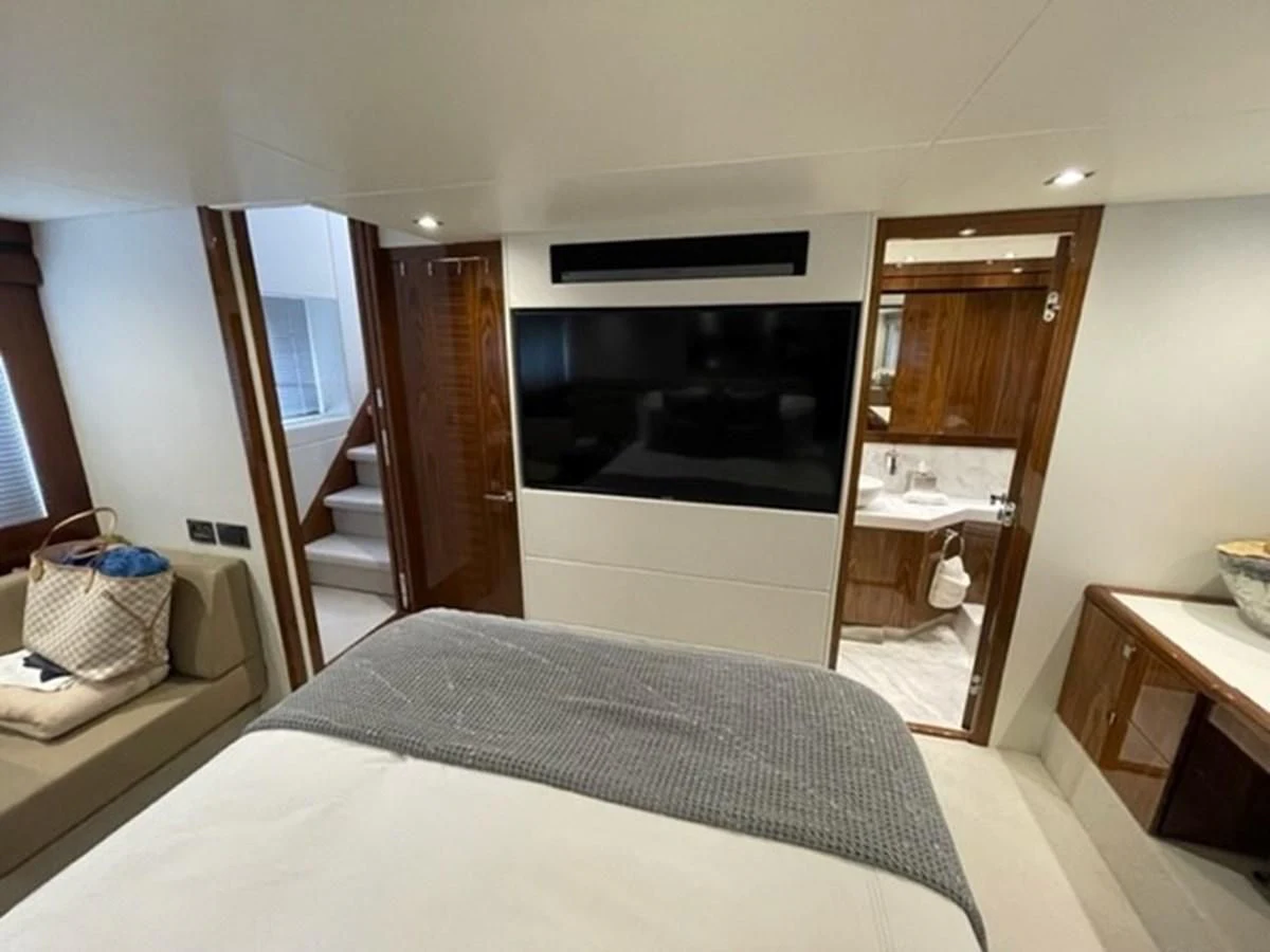 a bedroom with a bed and a television aboard EXIT Yacht for Sale