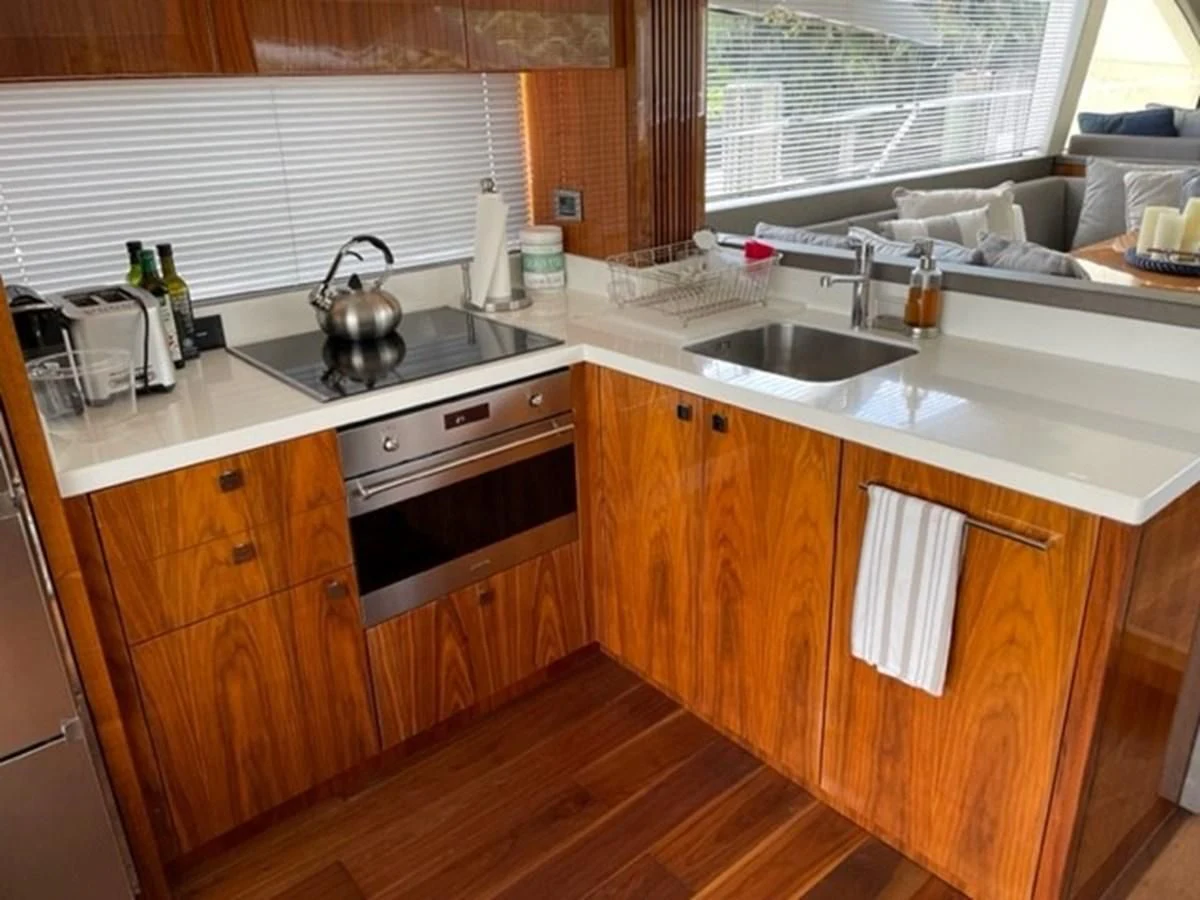 a kitchen with wooden cabinets aboard EXIT Yacht for Sale
