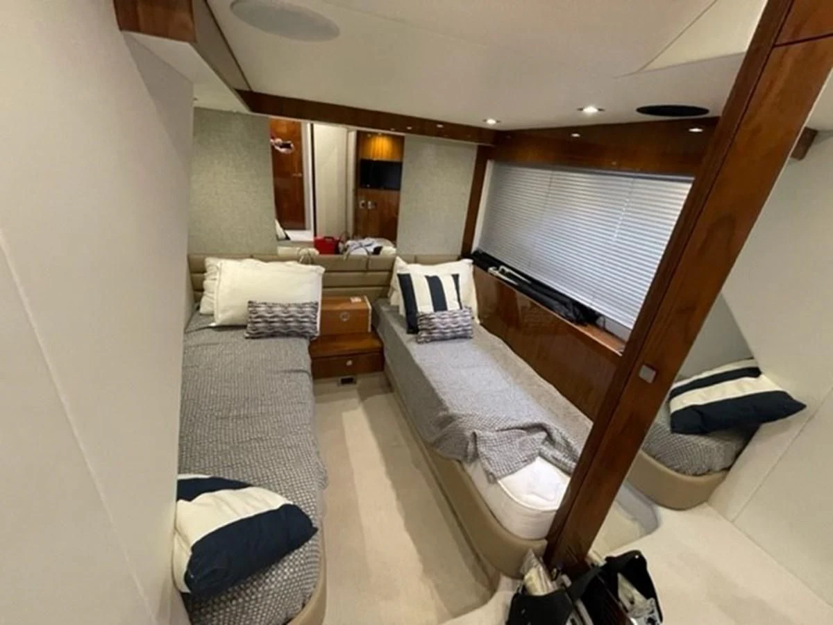 a bedroom with a bed and a window aboard EXIT Yacht for Sale