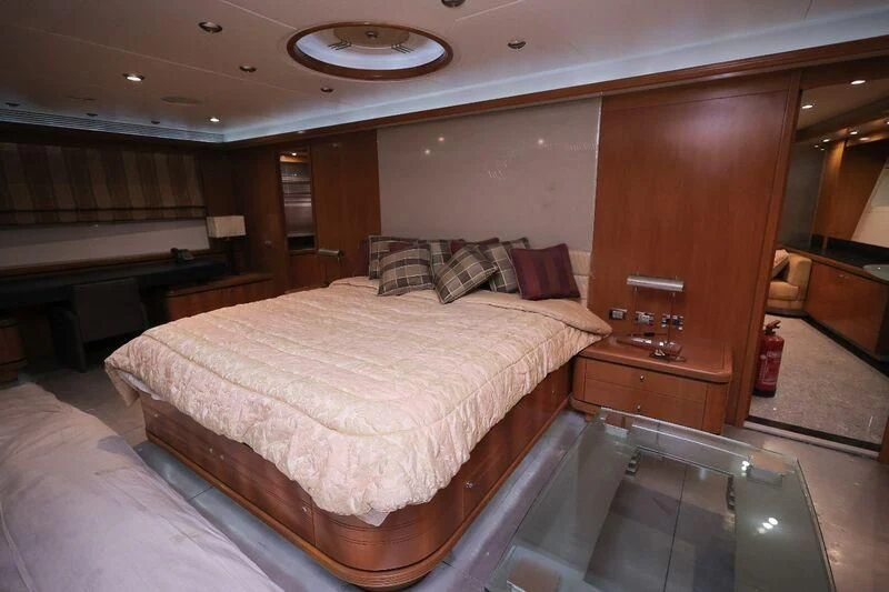 a room with a bed and a table aboard OCEAN 1 Yacht for Sale