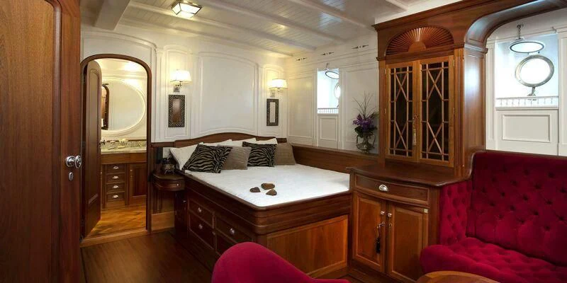 a bedroom with a bed and a red couch aboard ATLANTIC Yacht for Charter
