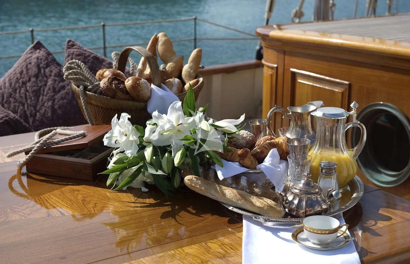a table with a basket of flowers and a book on it aboard ATLANTIC Yacht for Charter