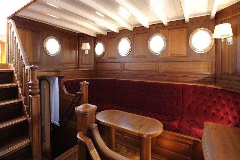a room with wooden walls and chandeliers aboard ATLANTIC Yacht for Charter