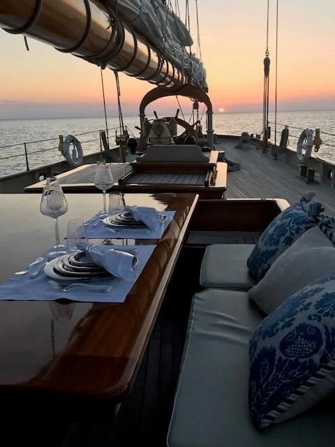 a table with a glass and a plate on it aboard ATLANTIC Yacht for Charter