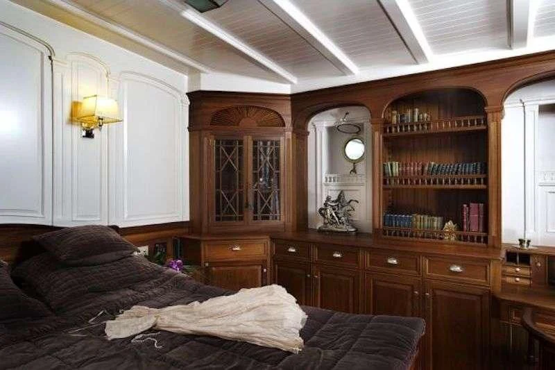 a bedroom with a bed and bookcase aboard ATLANTIC Yacht for Charter