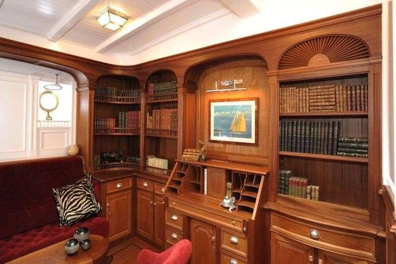 a living room with a book shelf aboard ATLANTIC Yacht for Charter