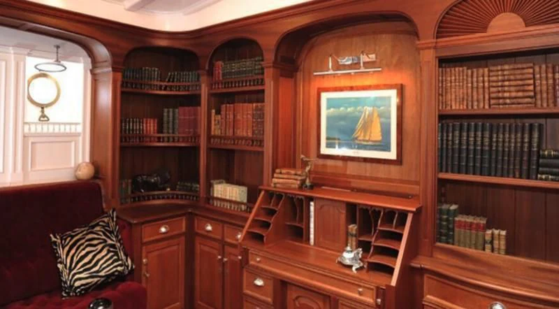 a living room with a tv and bookshelves aboard ATLANTIC Yacht for Charter