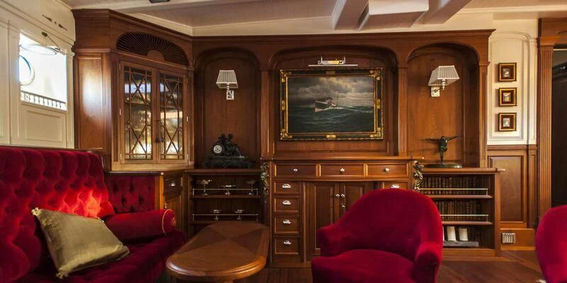 a living room with a red couch and a television aboard ATLANTIC Yacht for Charter