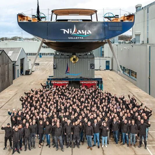 a group of people standing in front of a boat aboard NILAYA Yacht for Sale