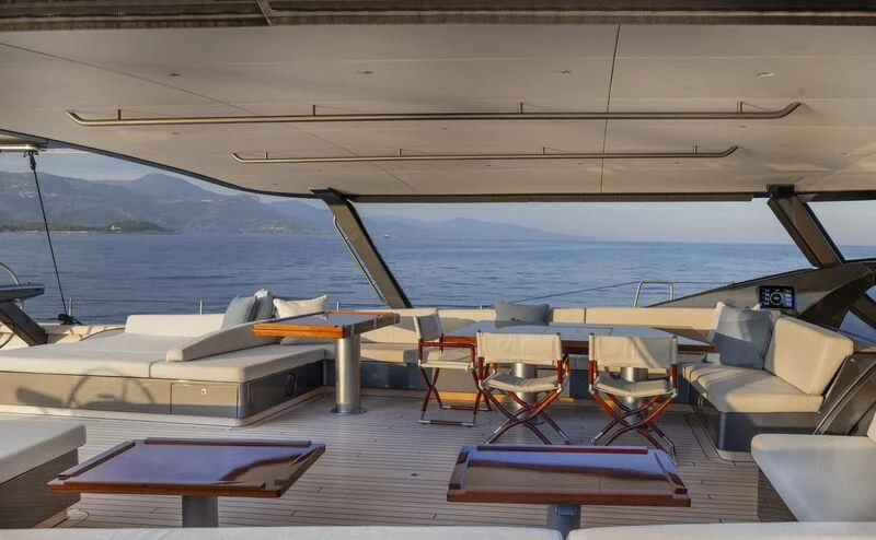 a deck with chairs and a boat on it aboard NILAYA Yacht for Sale