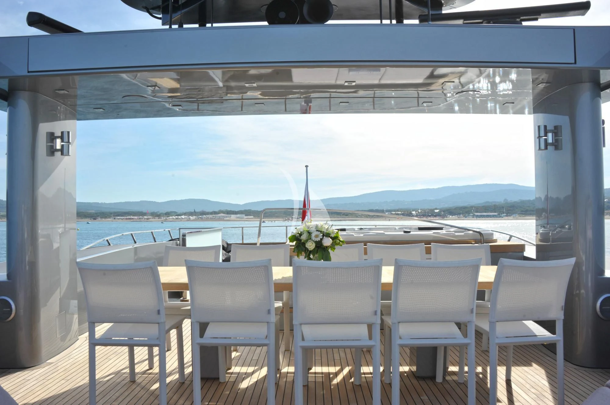 a table with white chairs and a flag on it aboard IROCK Yacht for Sale