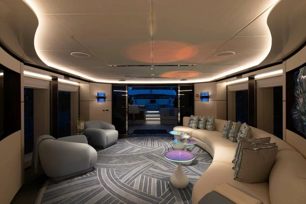 a large living room with a large white couch and a large white table aboard INFINITY Yacht for Sale