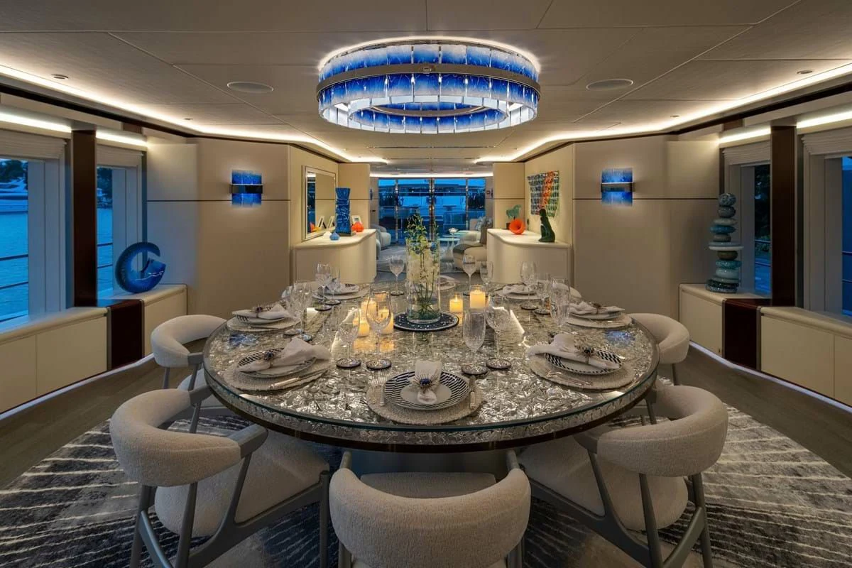 a large room with a round table and chairs aboard INFINITY Yacht for Sale
