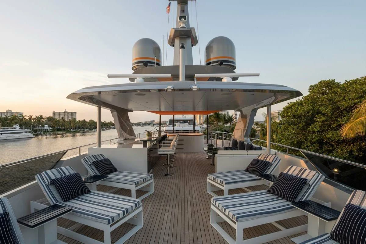 a deck with a deck chairs and a large ship on it aboard INFINITY Yacht for Sale