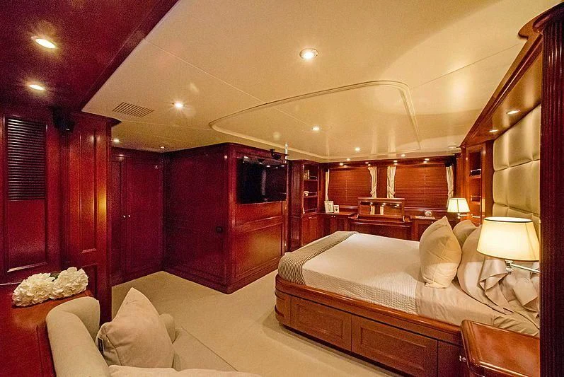 a bedroom with a bed and a dresser aboard HEAVEN CAN WAIT Yacht for Charter