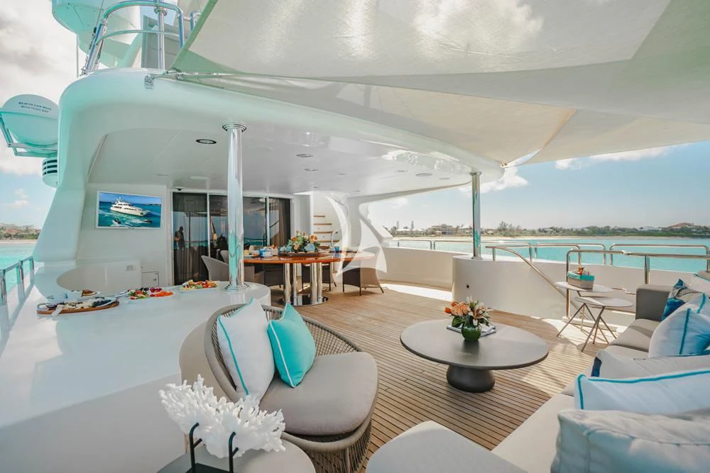 a lounge area with a lounge chair and a table and chairs aboard HEAVEN CAN WAIT Yacht for Charter