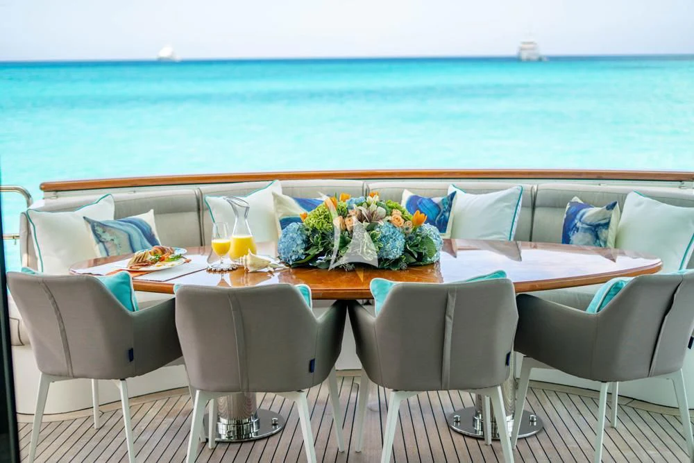 a table with a glass of juice and a view of the ocean aboard HEAVEN CAN WAIT Yacht for Charter