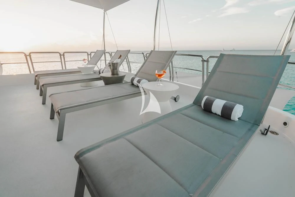 a room with a bed and a table with chairs aboard HEAVEN CAN WAIT Yacht for Charter