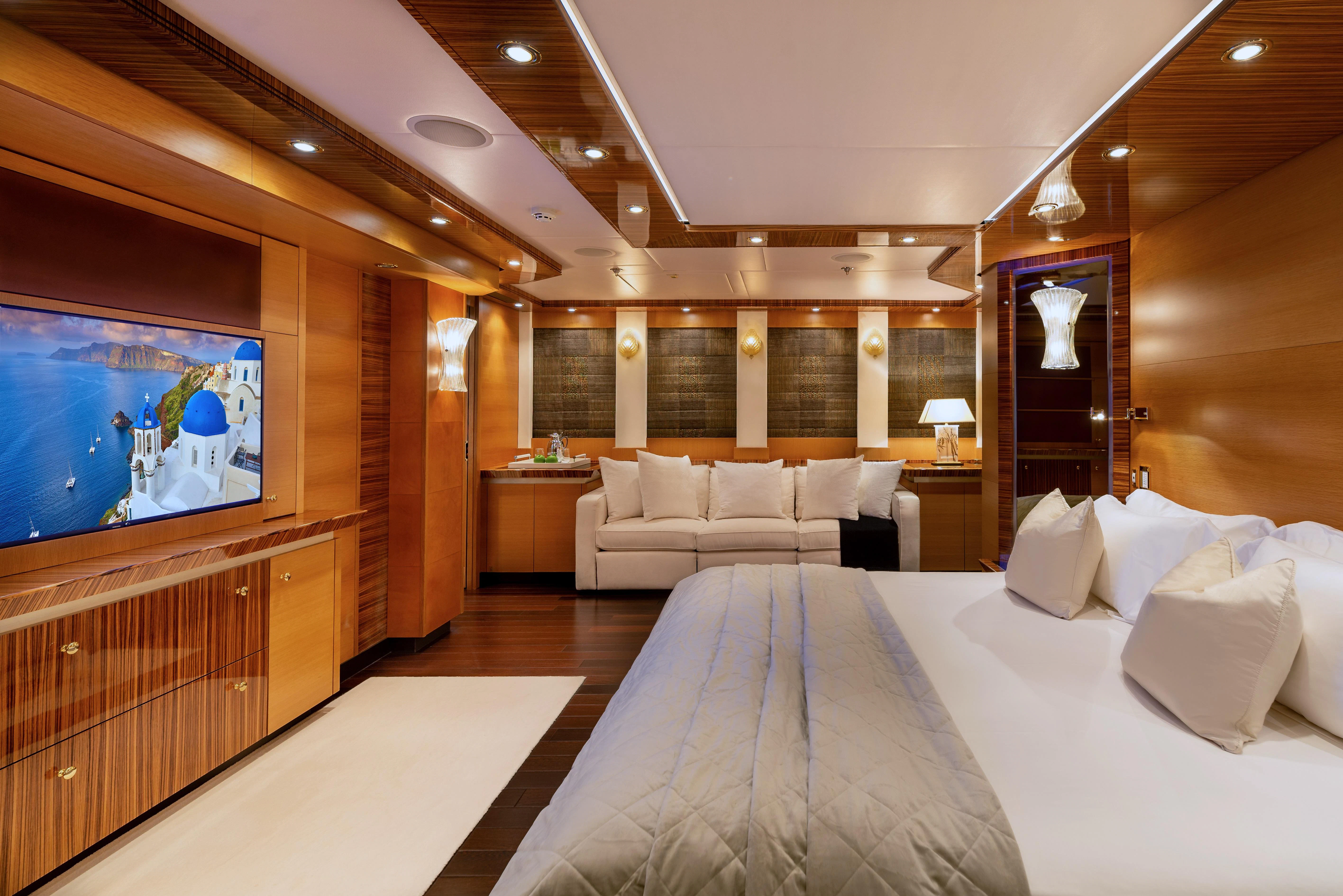 a large hotel room with a large bed and a large television aboard HOKULANI Yacht for Sale