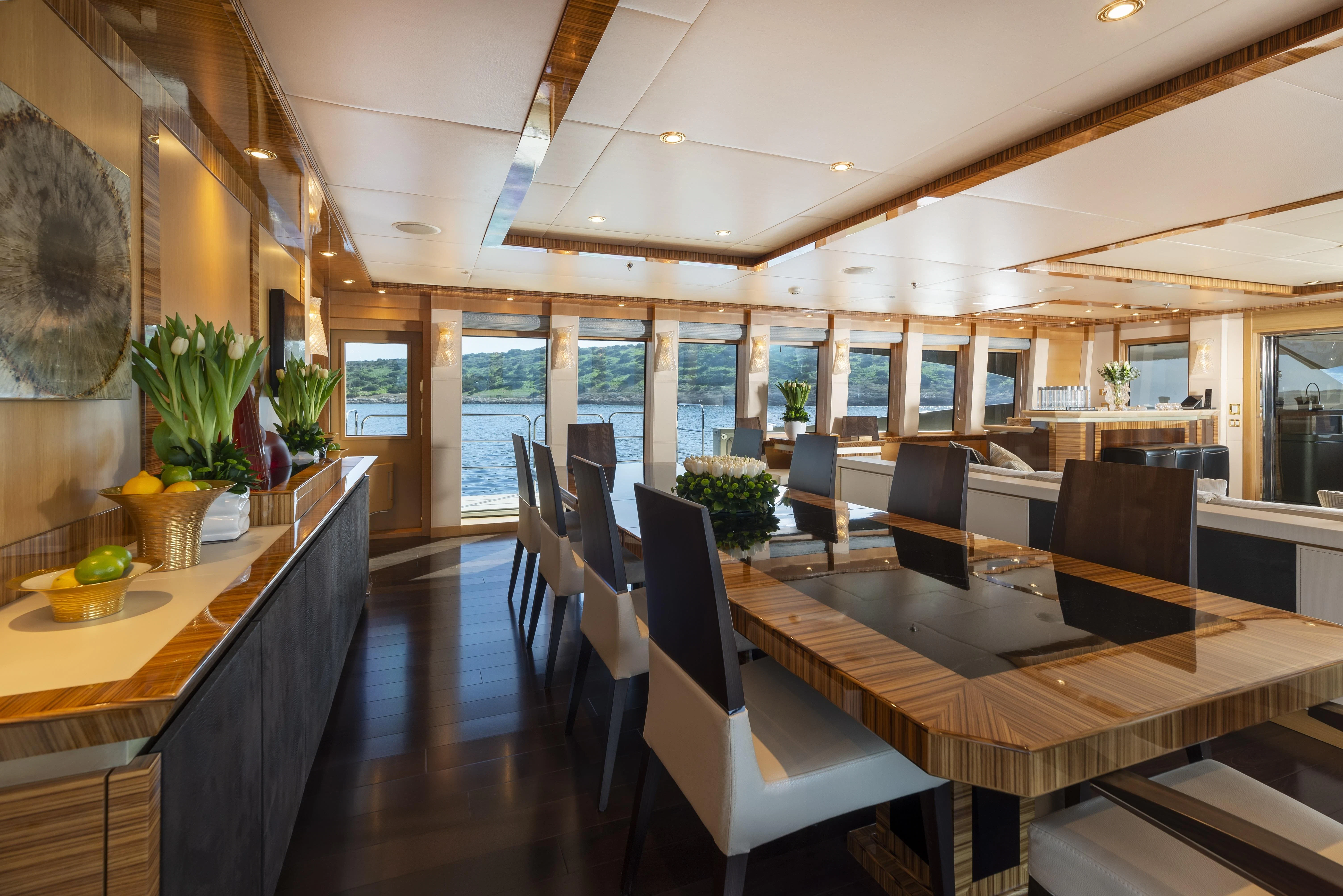 a room with a table chairs and plants aboard HOKULANI Yacht for Sale