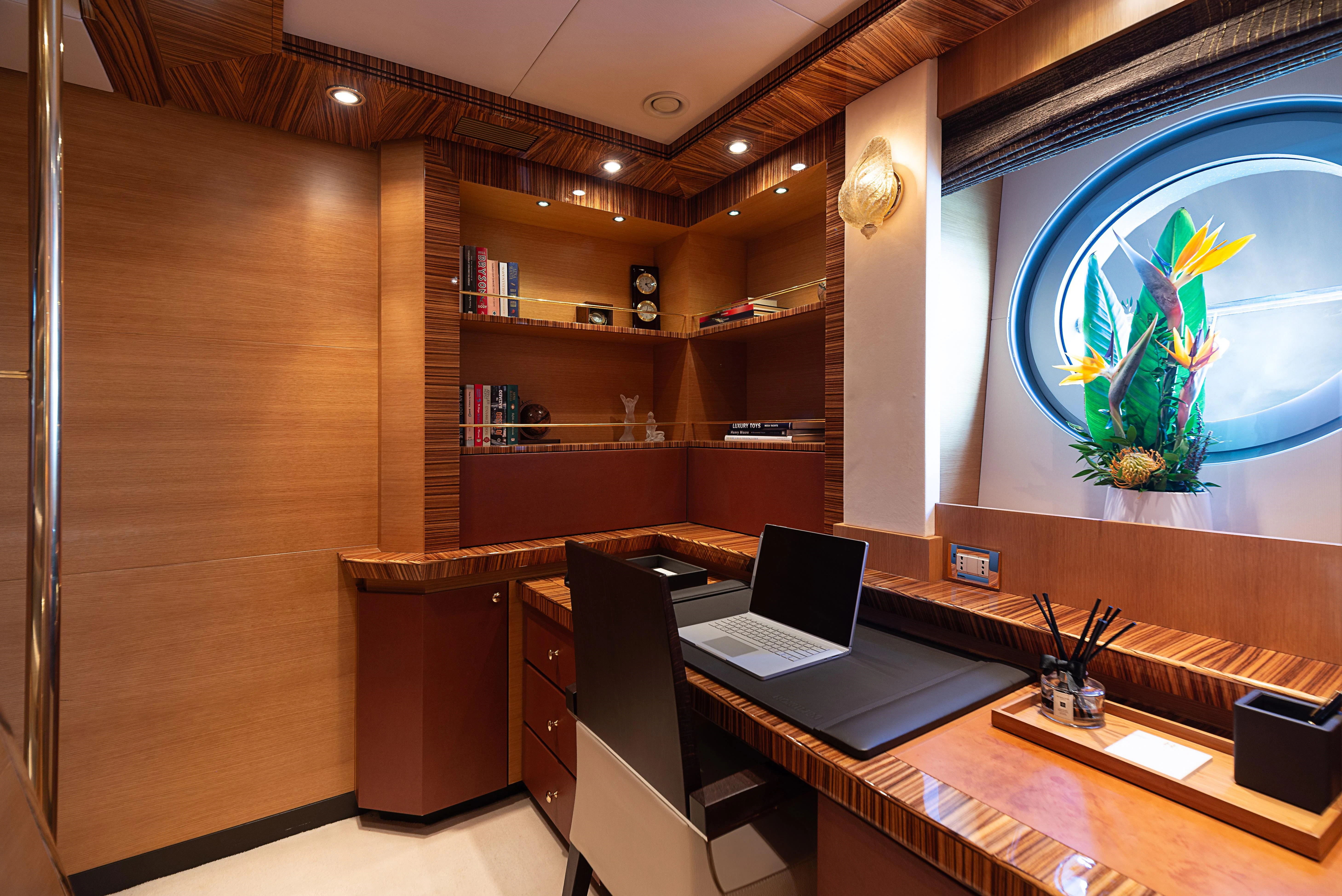 a room with a laptop and a tv on the wall aboard HOKULANI Yacht for Sale