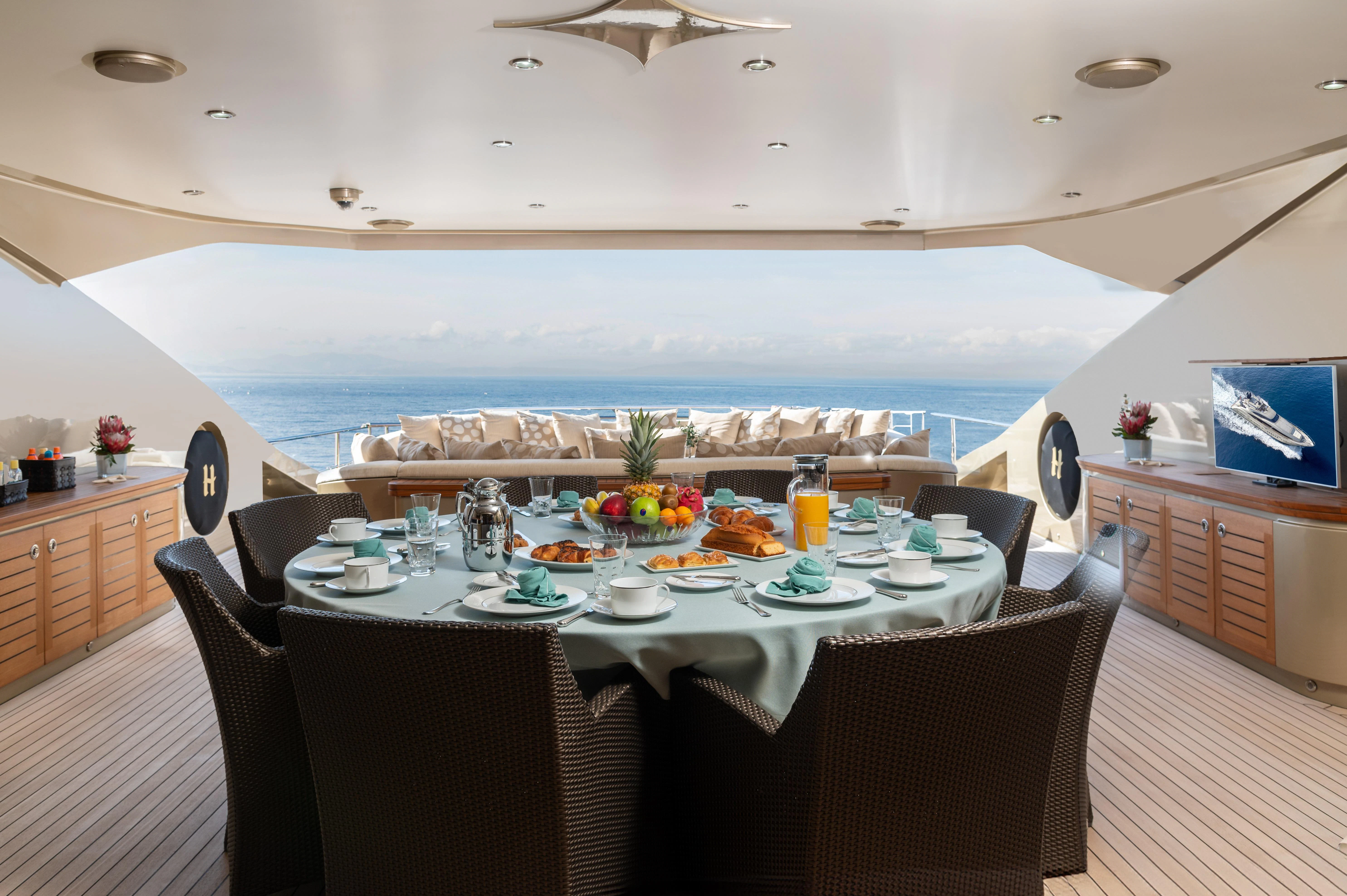 a dining table with a view of the water and the ocean aboard HOKULANI Yacht for Sale