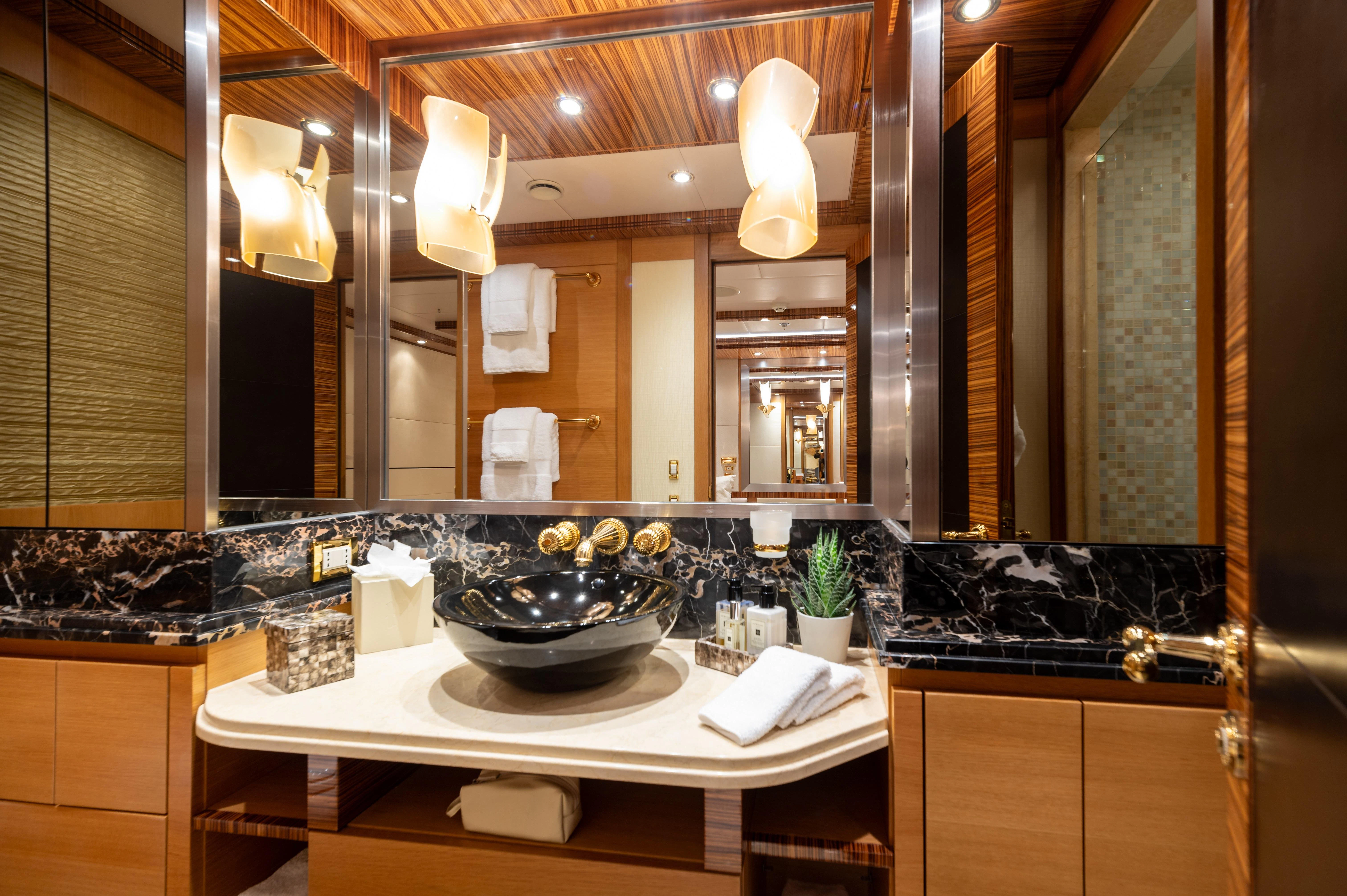 a bathroom with a sink and a large mirror aboard HOKULANI Yacht for Sale