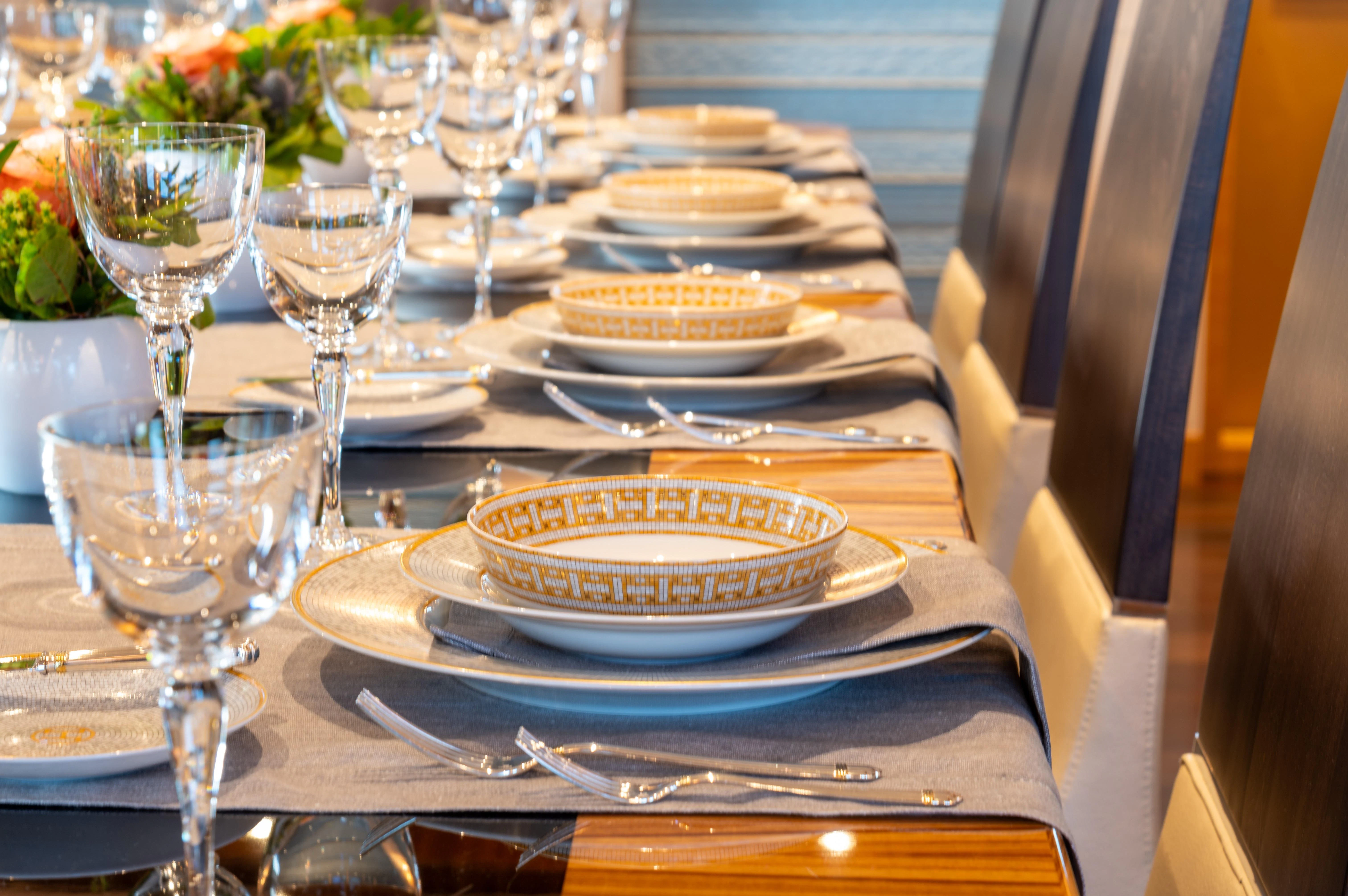 a table with plates and glasses aboard HOKULANI Yacht for Sale