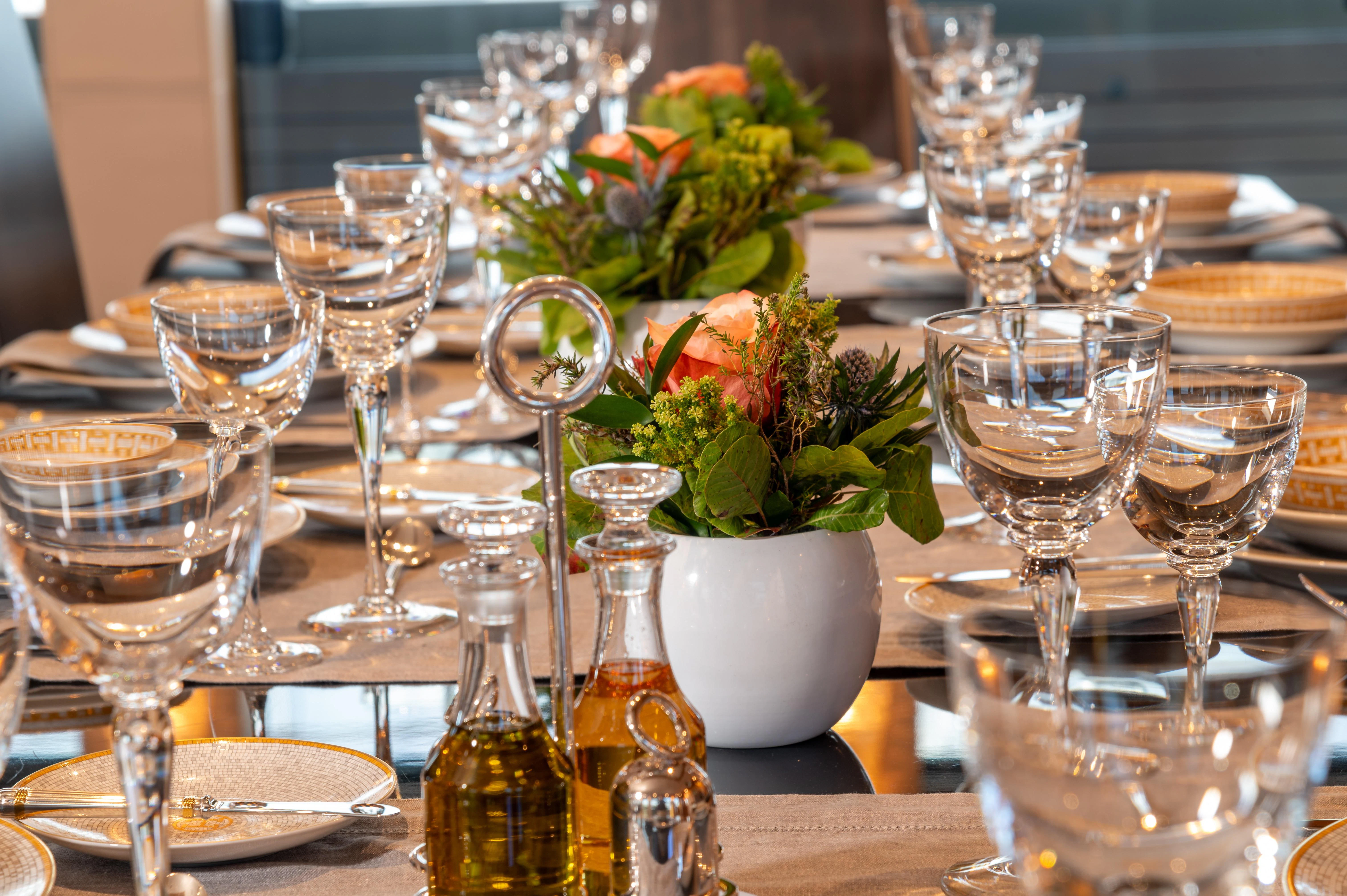 a table with wine glasses and plates aboard HOKULANI Yacht for Sale
