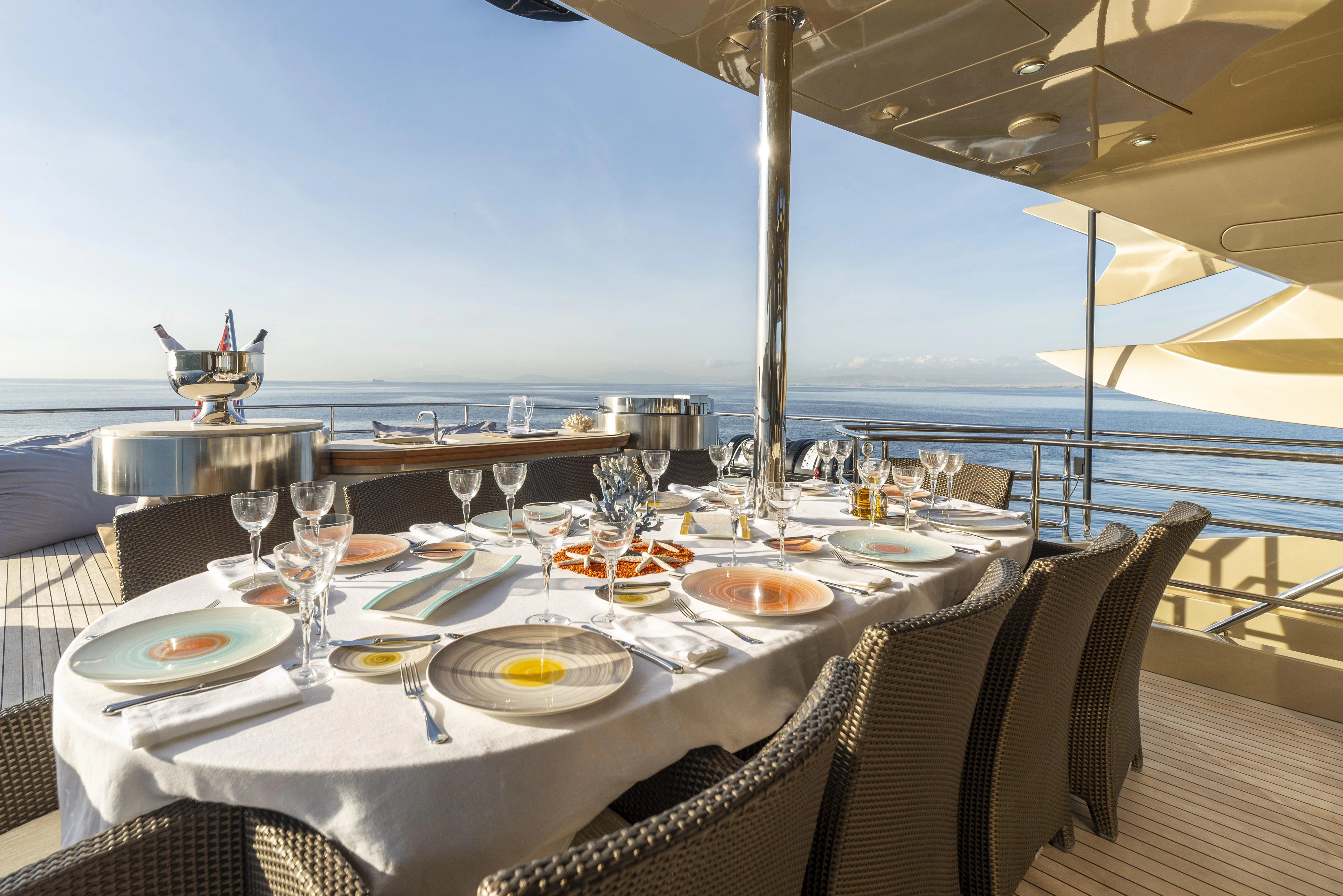 a table set for a meal on a deck overlooking the ocean aboard HOKULANI Yacht for Sale