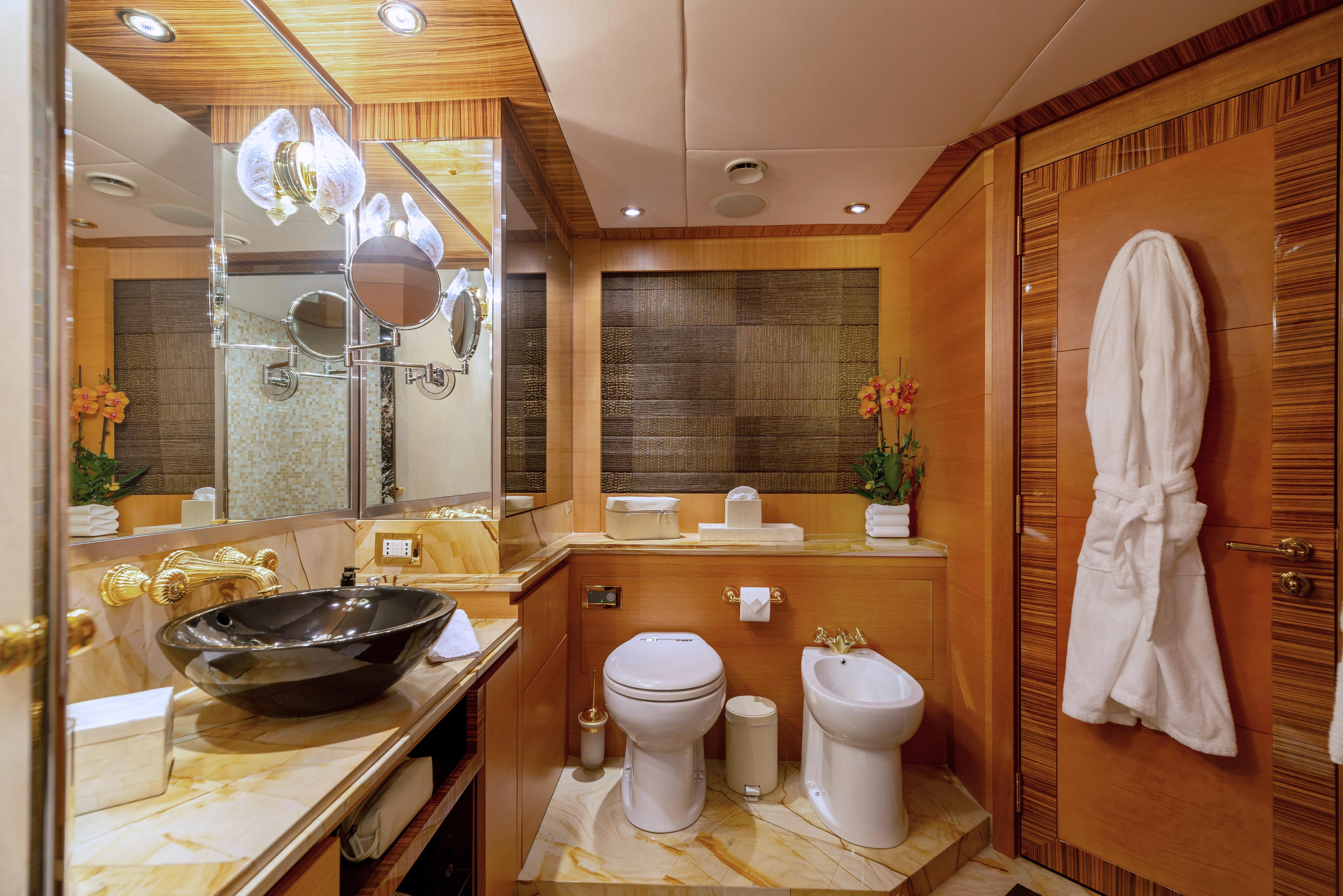 a bathroom with a sink toilet and a mirror aboard HOKULANI Yacht for Sale