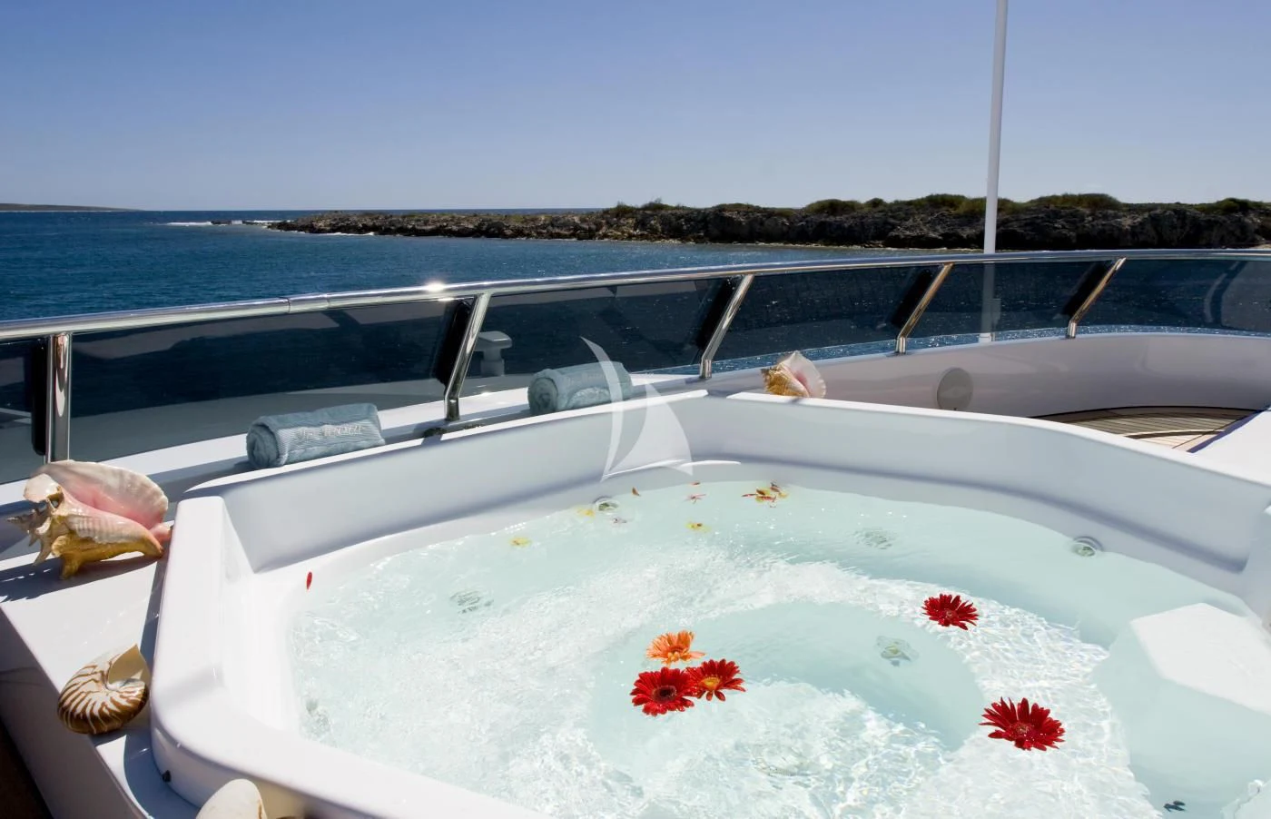 a white boat with red leaves on the water aboard TE MANU Yacht for Charter