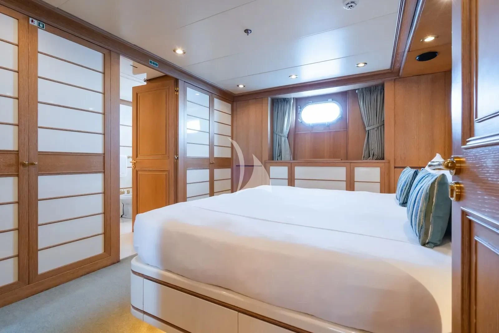 a bedroom with a bed and a closet aboard TE MANU Yacht for Charter