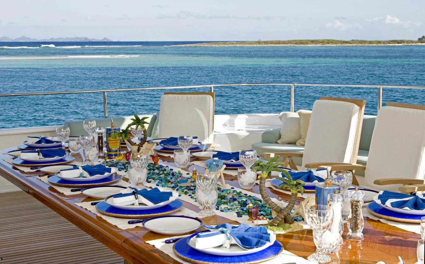 a table set for a dinner party aboard TE MANU Yacht for Charter