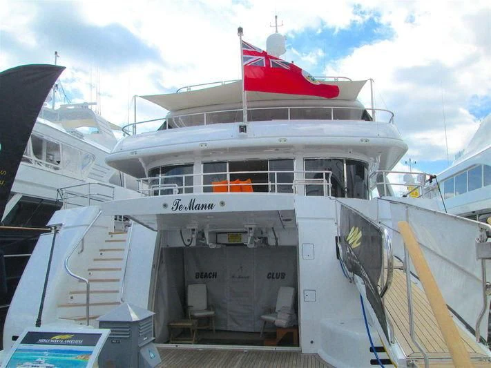 a large white boat with a flag on the front aboard TE MANU Yacht for Charter