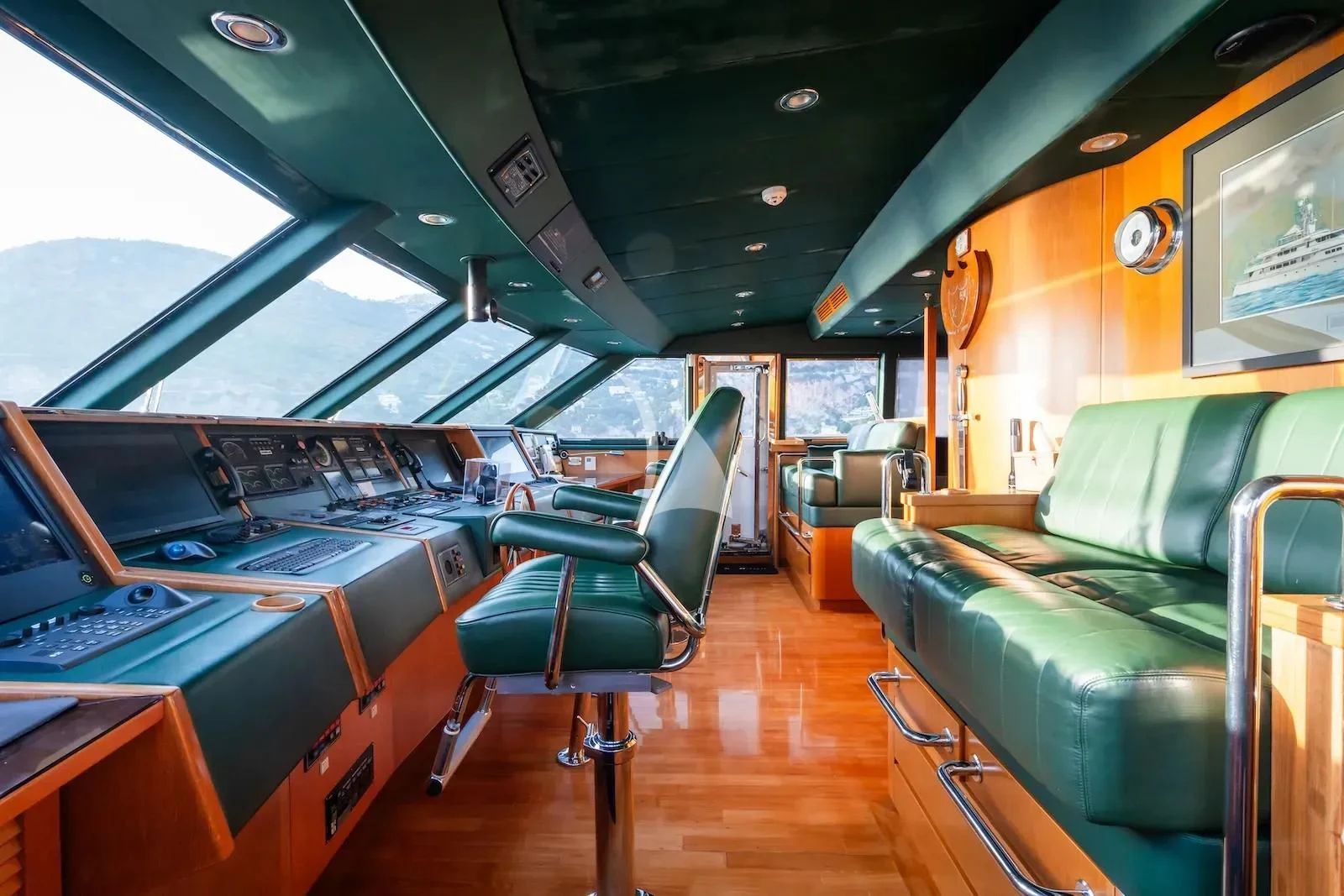 a room with a green couch and a green couch and a large window aboard TE MANU Yacht for Charter