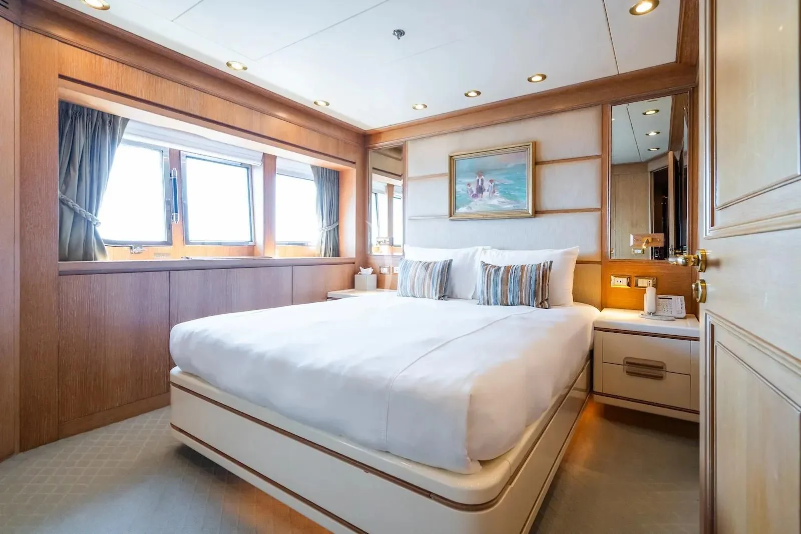 a bedroom with a bed and a mirror aboard TE MANU Yacht for Charter